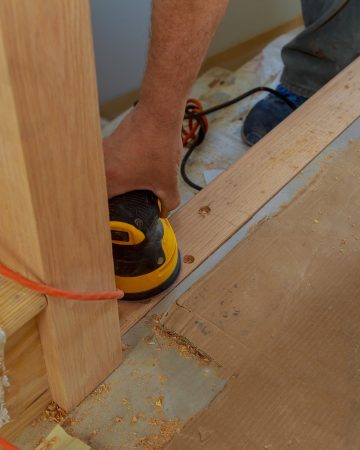 Carpeted in refinishing the stairwell of railing in a Sandpaper sanding
